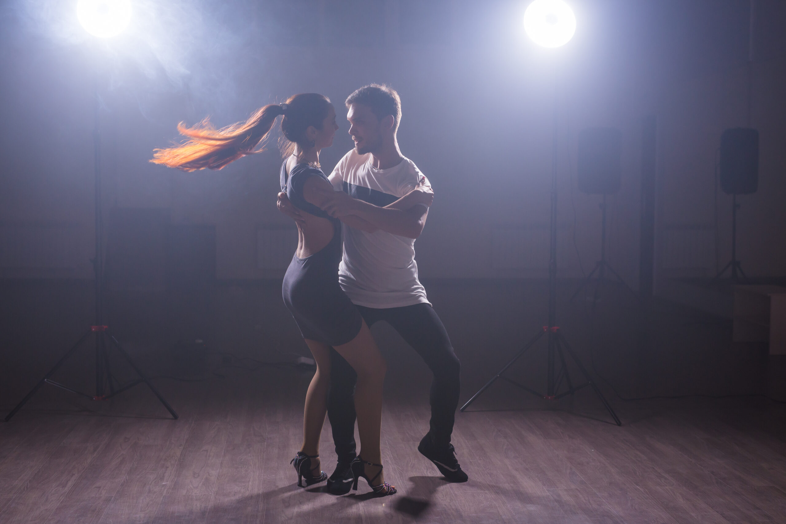 Active happy adults dancing bachata together in dance class