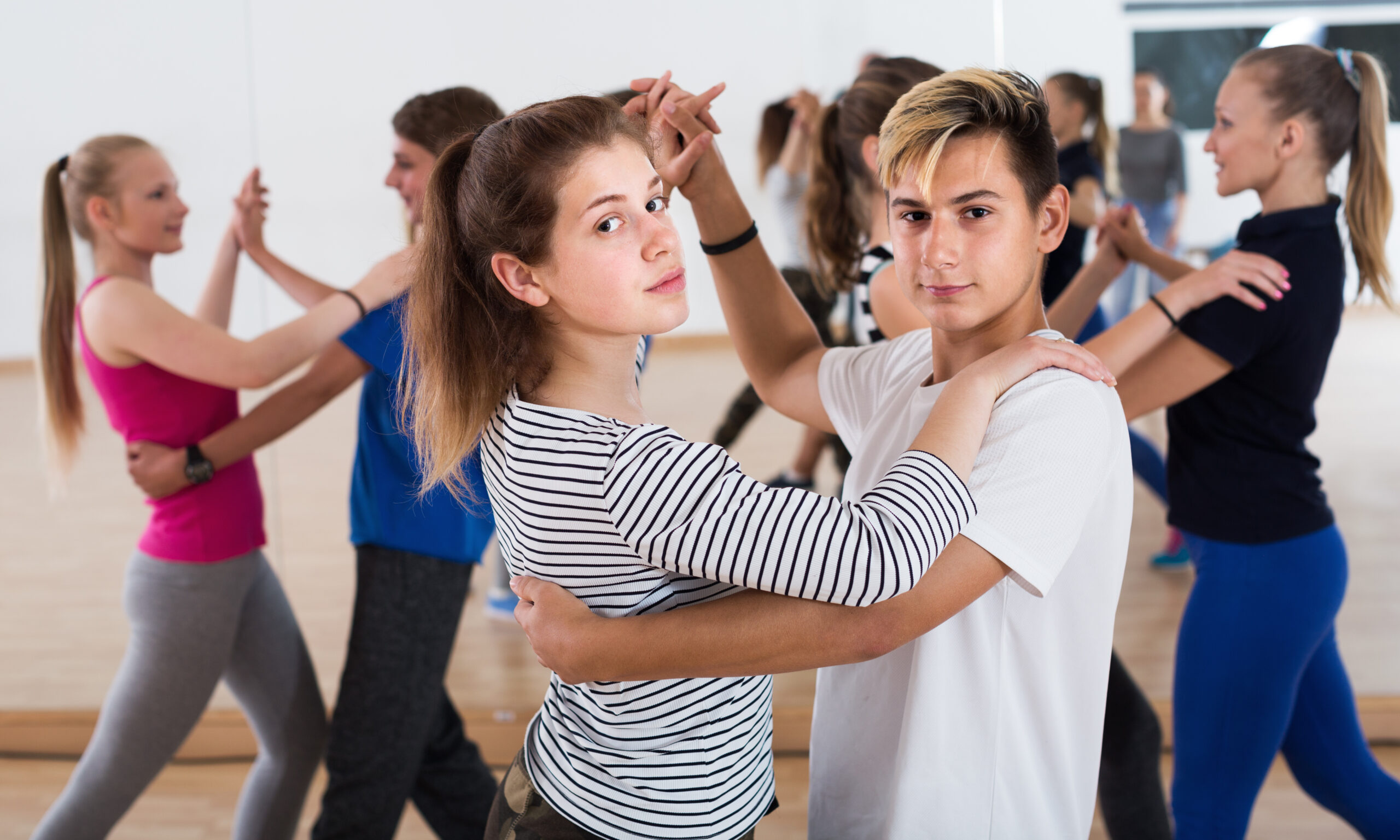 Positive couple of teenagers having dancing class